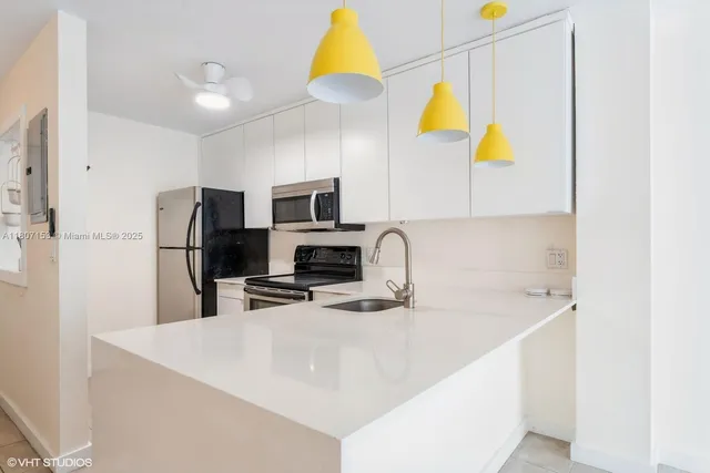 a kitchen with stainless steel appliances a sink a microwave a refrigerator and a stove