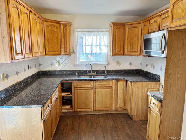 a kitchen with granite countertop a sink stove and cabinets