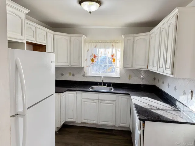 a kitchen with granite countertop a sink and cabinets