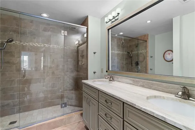 a bathroom with a shower sink and mirror