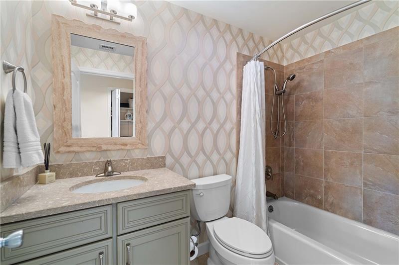 3475 Oak Valley Road Northeast, Unit 470 Atlanta, GA 30326 - Photo 20 of 34 a bathroom with a granite countertop sink a toilet and shower