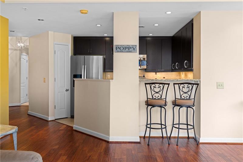 3475 Oak Valley Road Northeast, Unit 470 Atlanta, GA 30326 - Photo 6 of 34 a view of kitchen with stainless steel appliances wooden floor and chair