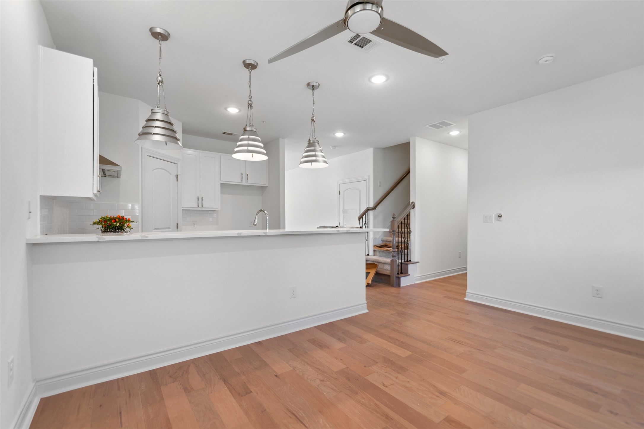2105 Tiger Trail, Unit 103 Round Rock, TX 78664 - Photo 17 of 38 Kitchen featuring white cabinetry, pendant lighting, light wood finished floors, and a ceiling fan