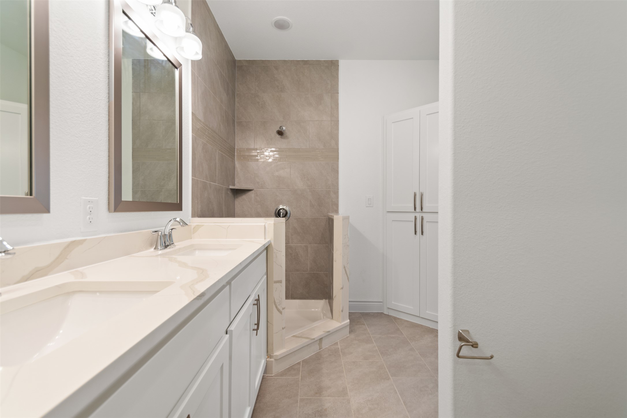 2105 Tiger Trail, Unit 103 Round Rock, TX 78664 - Photo 23 of 38 Primary Bathroom with double vanity, a tile shower, and light tile patterned flooring