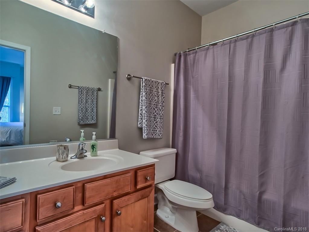 4136 Walker Road Charlotte, NC 28211 - Photo 9 of 15 a bathroom with a sink a toilet a mirror and shower curtain