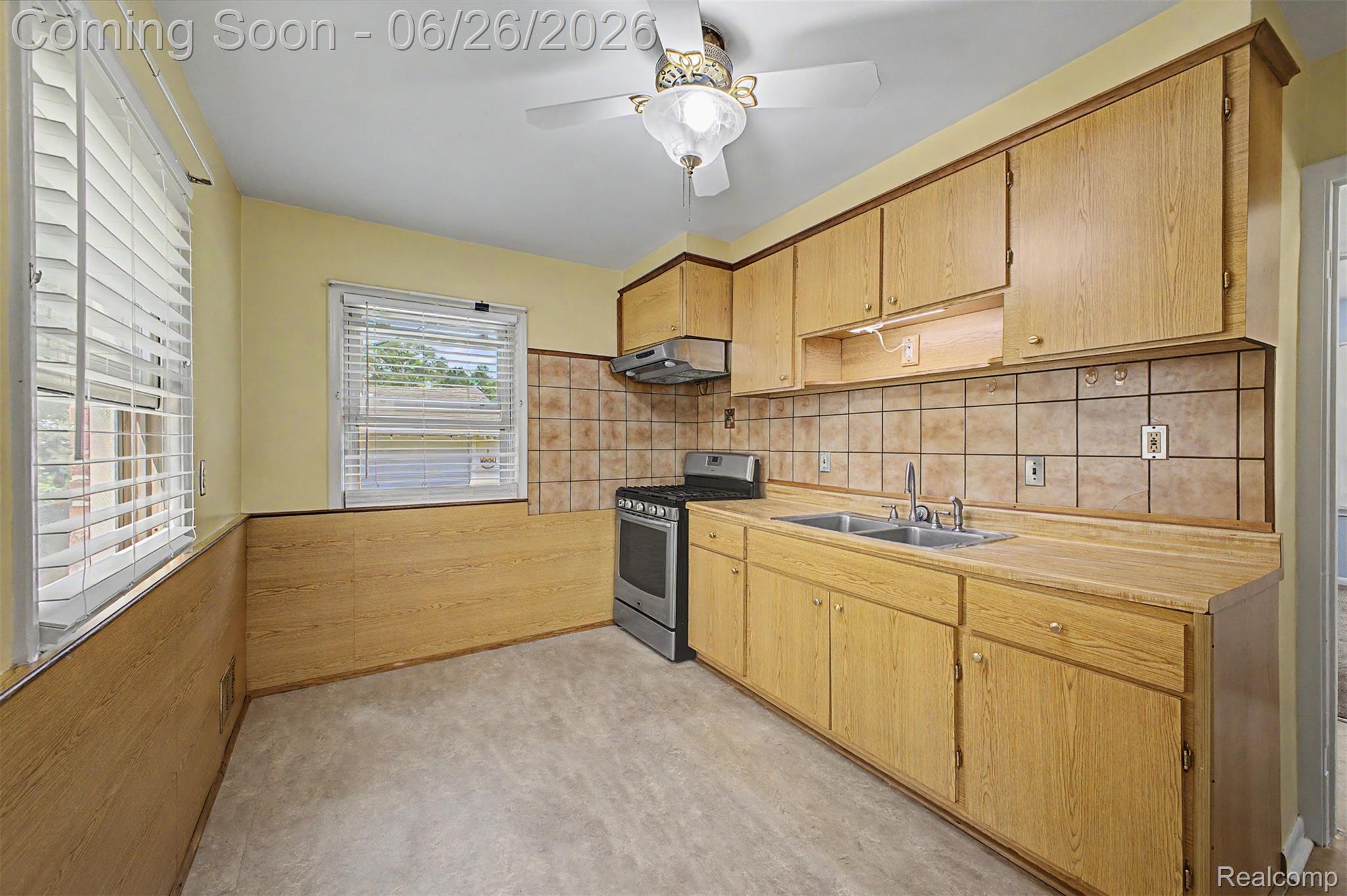 2216 Banner Street Dearborn, MI 48124 - Photo 15 of 34 Kitchen featuring wood-finish cabinetry, a stainless steel range, a double basin sink, and tile backsplash