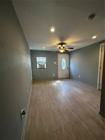 an empty room with window and wooden floor