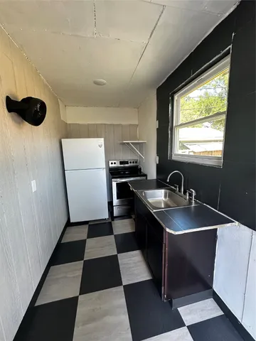 a kitchen with a sink a refrigerator and a stove