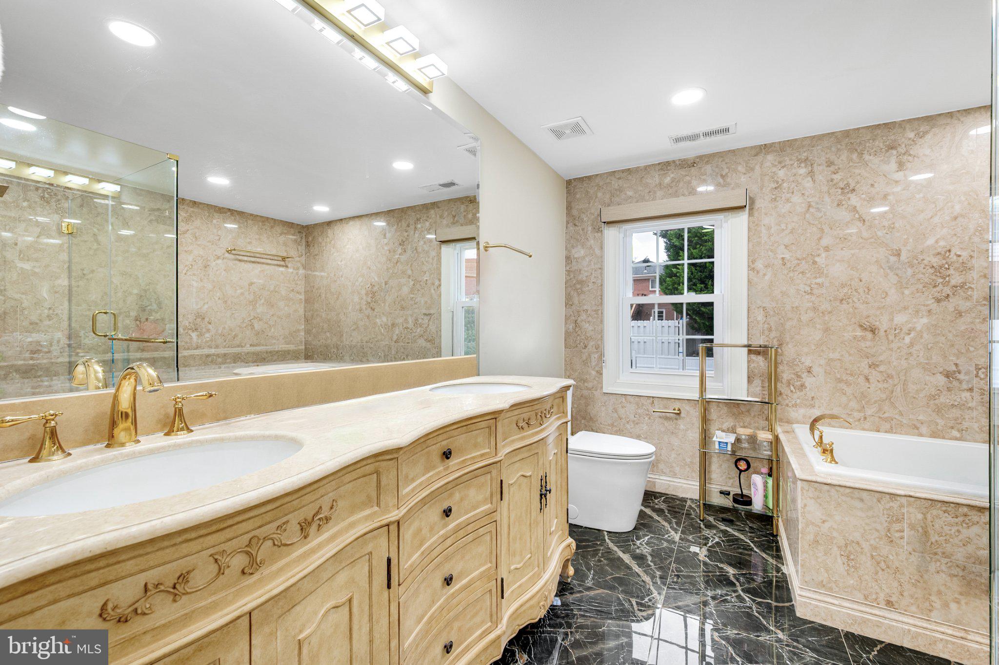 10904 Gainsborough Road Potomac, MD 20854 - Photo 7 of 32 Elegant marble bath with golden accents.