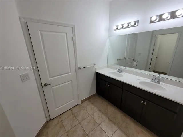a spacious bathroom with a double vanity sink a and mirror