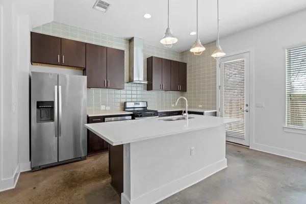 a kitchen with kitchen island a sink stove and refrigerator