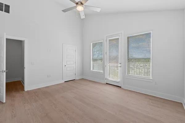 an empty room with chandelier fan