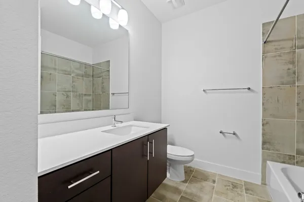 a bathroom with a sink a toilet a mirror and shower