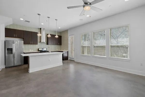 a view of kitchen with kitchen island stainless steel appliances sink microwave and stove