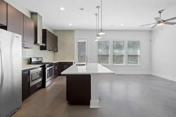 a kitchen with stainless steel appliances granite countertop a stove a sink and a refrigerator