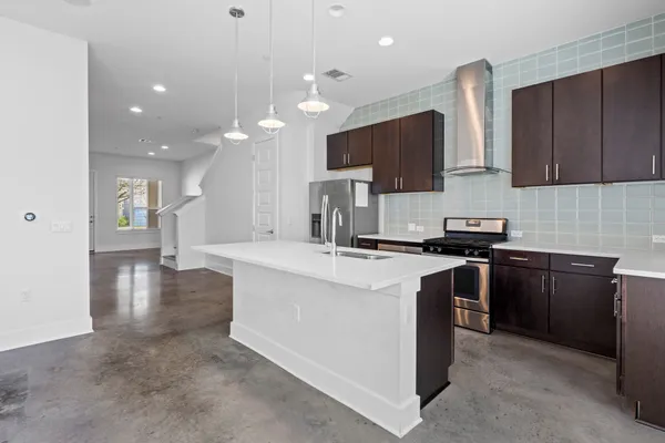 a kitchen with stainless steel appliances granite countertop a sink stove and refrigerator