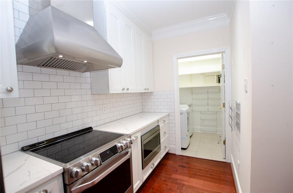 4100 Paces Walk Southeast, Unit 1305 Atlanta, GA 30339 - Photo 21 of 45 a kitchen with a stove and a wooden floor
