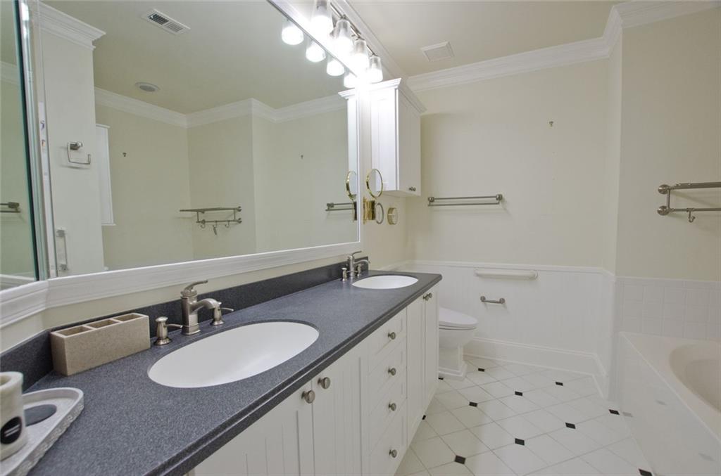 4100 Paces Walk Southeast, Unit 1305 Atlanta, GA 30339 - Photo 28 of 45 a bathroom with a granite countertop sink mirror and a bathtub