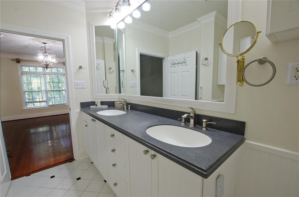 4100 Paces Walk Southeast, Unit 1305 Atlanta, GA 30339 - Photo 29 of 45 a bathroom with a granite countertop sink and a mirror