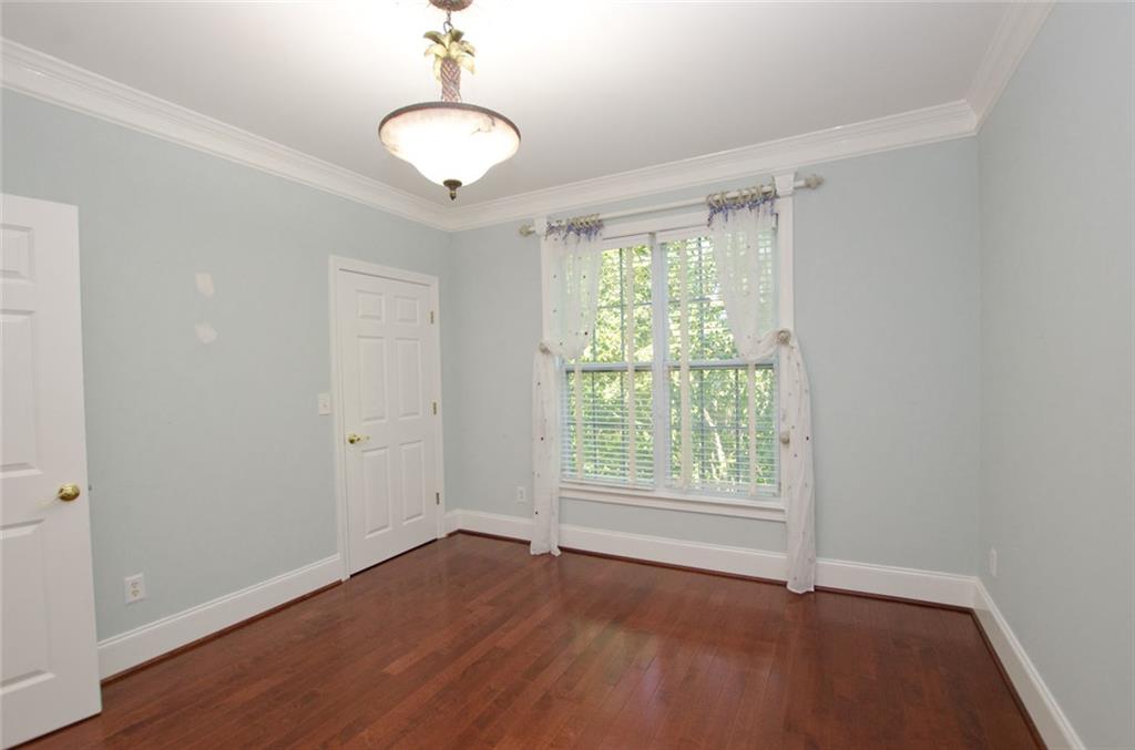 4100 Paces Walk Southeast, Unit 1305 Atlanta, GA 30339 - Photo 39 of 45 an empty room with wooden floor and windows