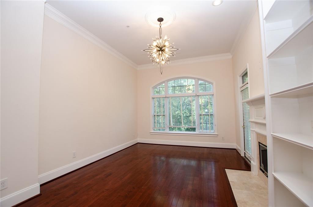4100 Paces Walk Southeast, Unit 1305 Atlanta, GA 30339 - Photo 8 of 45 an empty room with wooden floor chandelier and window