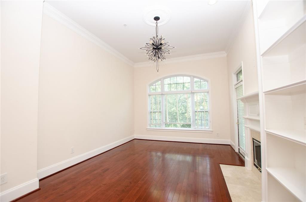 4100 Paces Walk Southeast, Unit 1305 Atlanta, GA 30339 - Photo 9 of 45 an empty room with wooden floor chandelier and windows