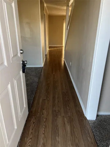 a view of a hallway with wooden floor and staircase