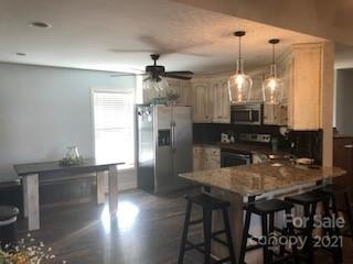 2270 Miller Road Salisbury, NC 28147 - Photo 23 of 33 a kitchen with stainless steel appliances kitchen island granite countertop a table chairs and a refrigerator