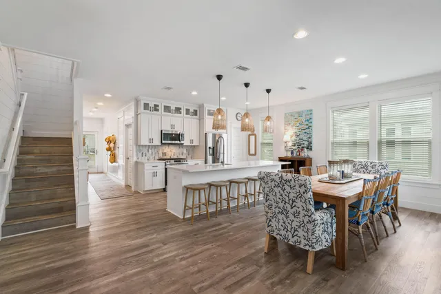 a kitchen with stainless steel appliances kitchen island granite countertop a stove a sink dishwasher and a refrigerator with wooden floor