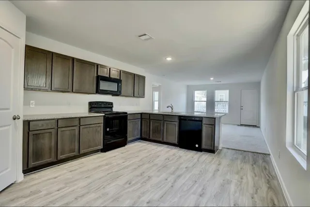 a kitchen with stainless steel appliances kitchen island granite countertop a stove a sink dishwasher and a refrigerator