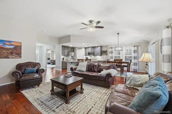 a living room with furniture kitchen view and a chandelier