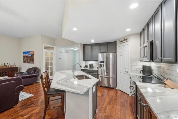 a open kitchen with stainless steel appliances granite countertop a sink refrigerator and cabinets