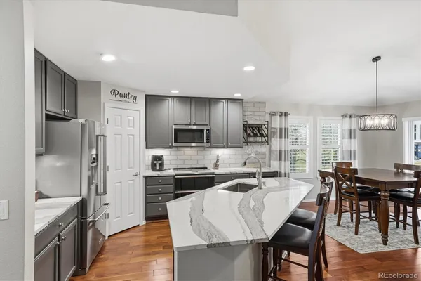 a kitchen with kitchen island granite countertop a center island stainless steel appliances cabinets and furniture