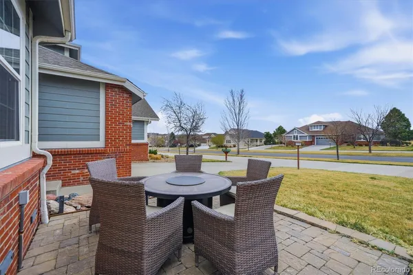 a view of a patio with dining table and chairs with wooden floor and fence