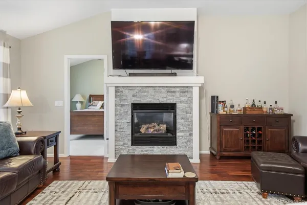 a living room with furniture a flat screen tv and a fireplace