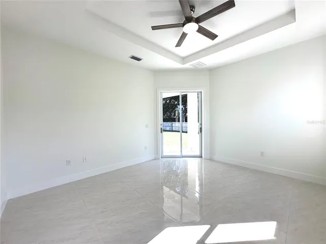 en empty room with windows and ceiling fan
