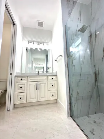 a bathroom with a double vanity sink mirror and shower