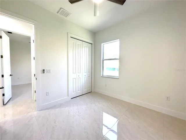 an empty room with windows and cabinet