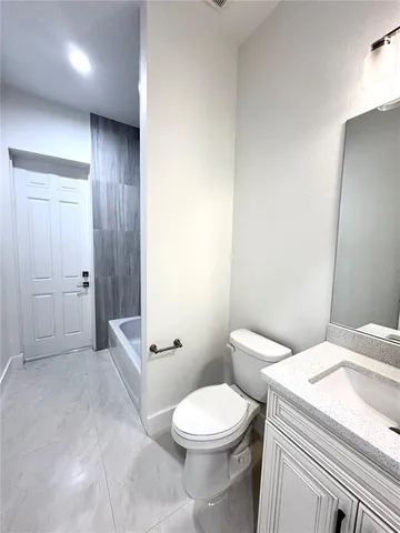 a white toilet sitting next to a bathroom sink