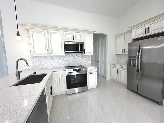 a kitchen with stainless steel appliances granite countertop a refrigerator sink and stove