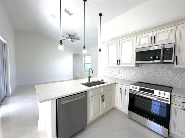 a kitchen with appliances a sink and cabinets