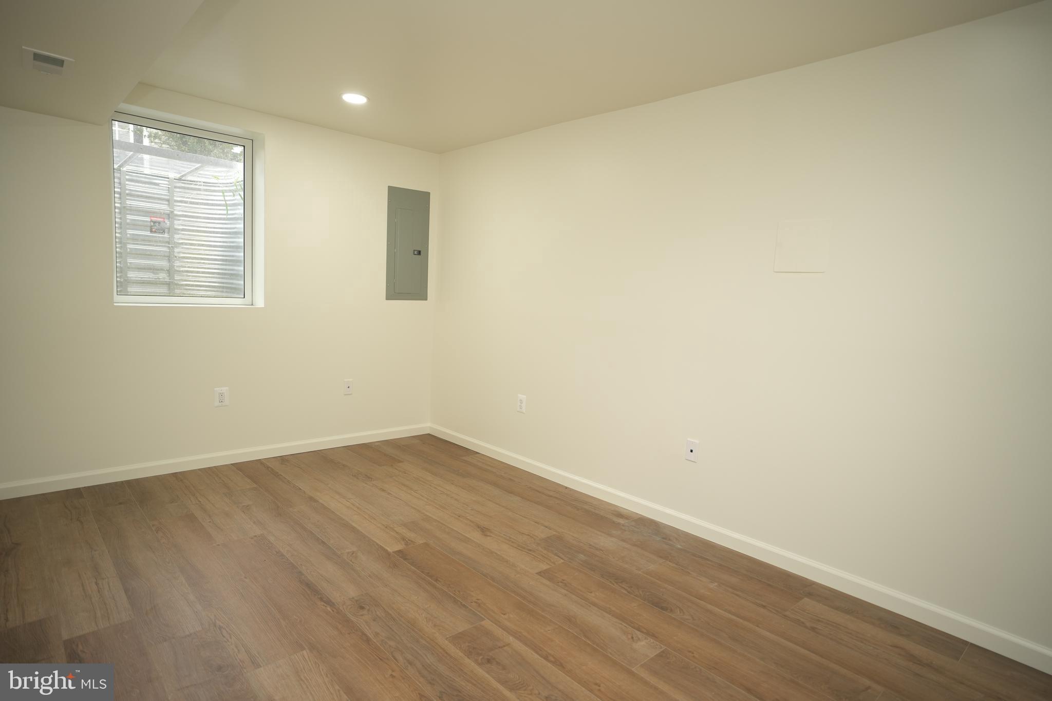 22271 Goldenrod Drive, Unit BASEMENT APARTMENT Great Mills, MD 20634 - Photo 11 of 15 an empty room with wooden floor and windows
