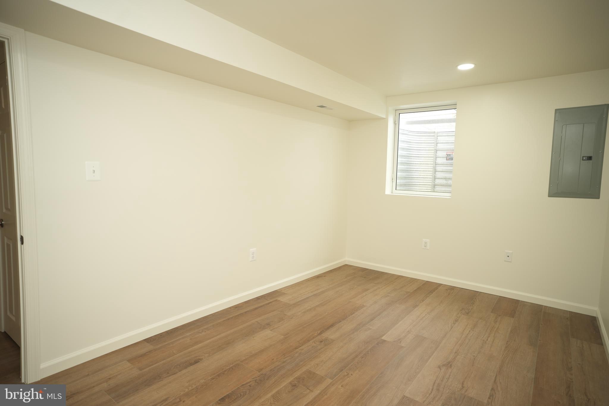 22271 Goldenrod Drive, Unit BASEMENT APARTMENT Great Mills, MD 20634 - Photo 9 of 15 an empty room with wooden floor and windows