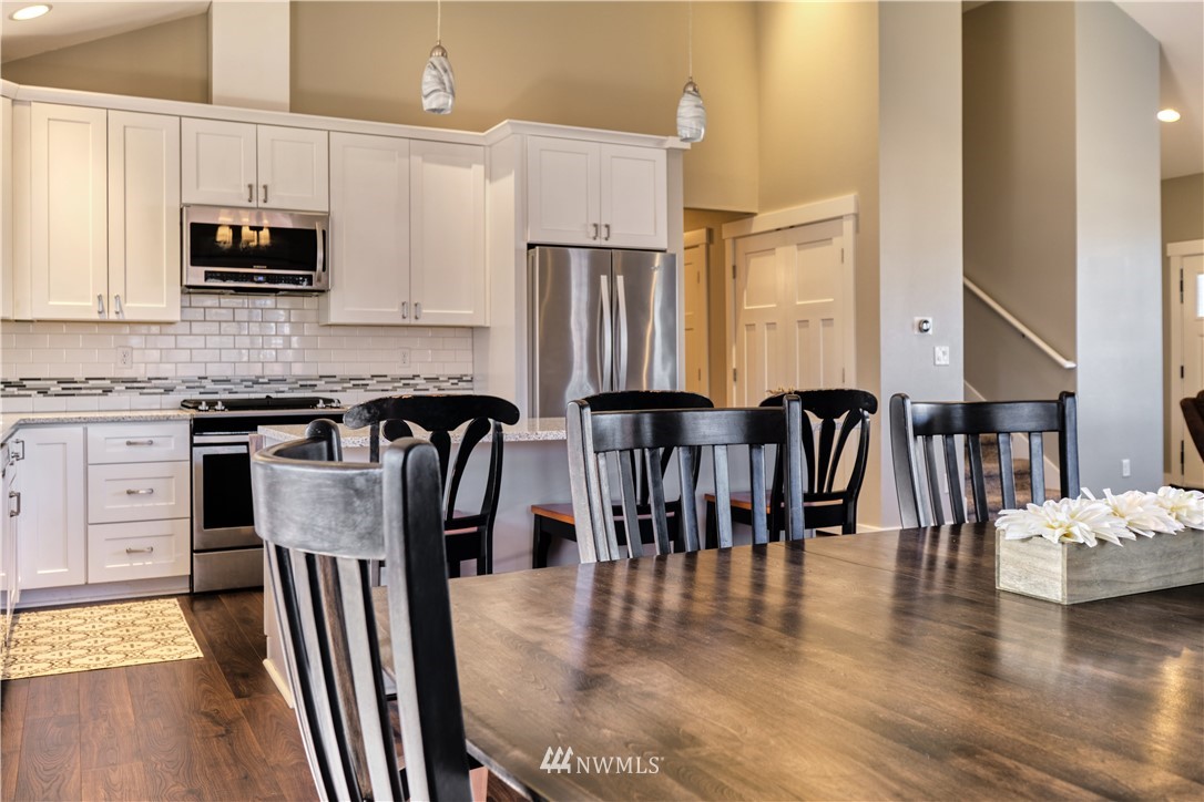 1007 Ridge Lane Everson, WA 98247 - Photo 10 of 25 a kitchen with stainless steel appliances granite countertop a stove top oven a sink a dining table and chairs