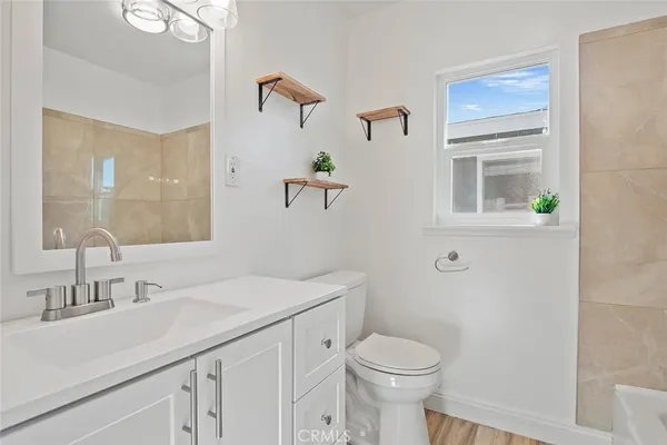 a bathroom with a sink a toilet and a mirror