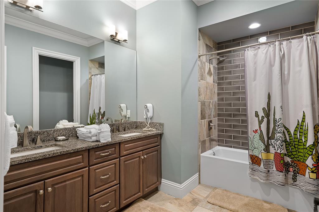 1261 Radiant Street Reunion, FL 34747 - Photo 78 of 100 a bathroom with a granite countertop sink and a mirror