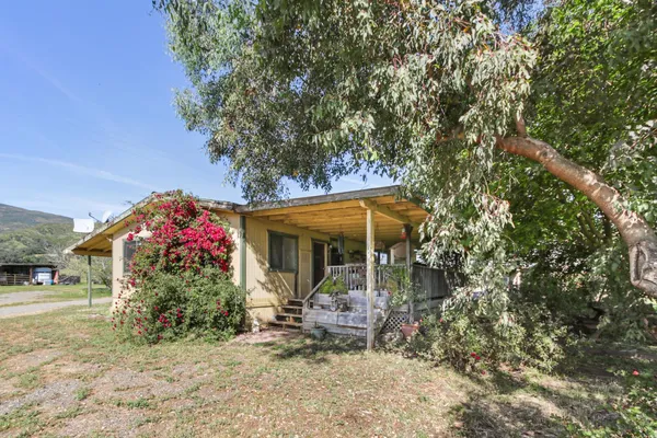 a view of a house with yard and sitting area