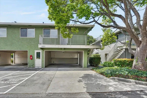 a front view of a house with yard and parking