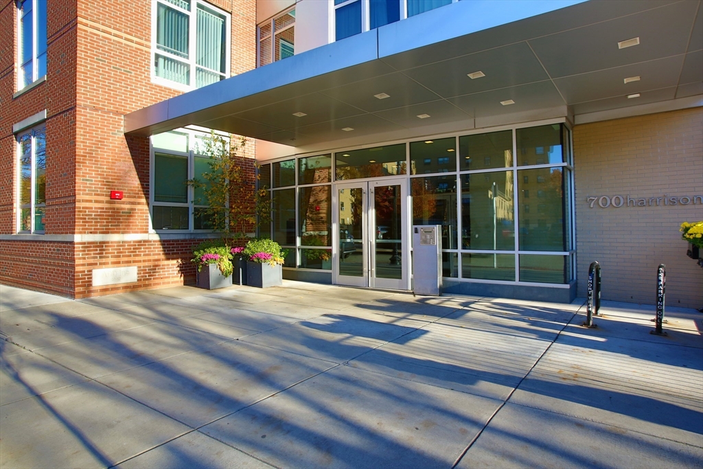 a view of a building with a large window and plants