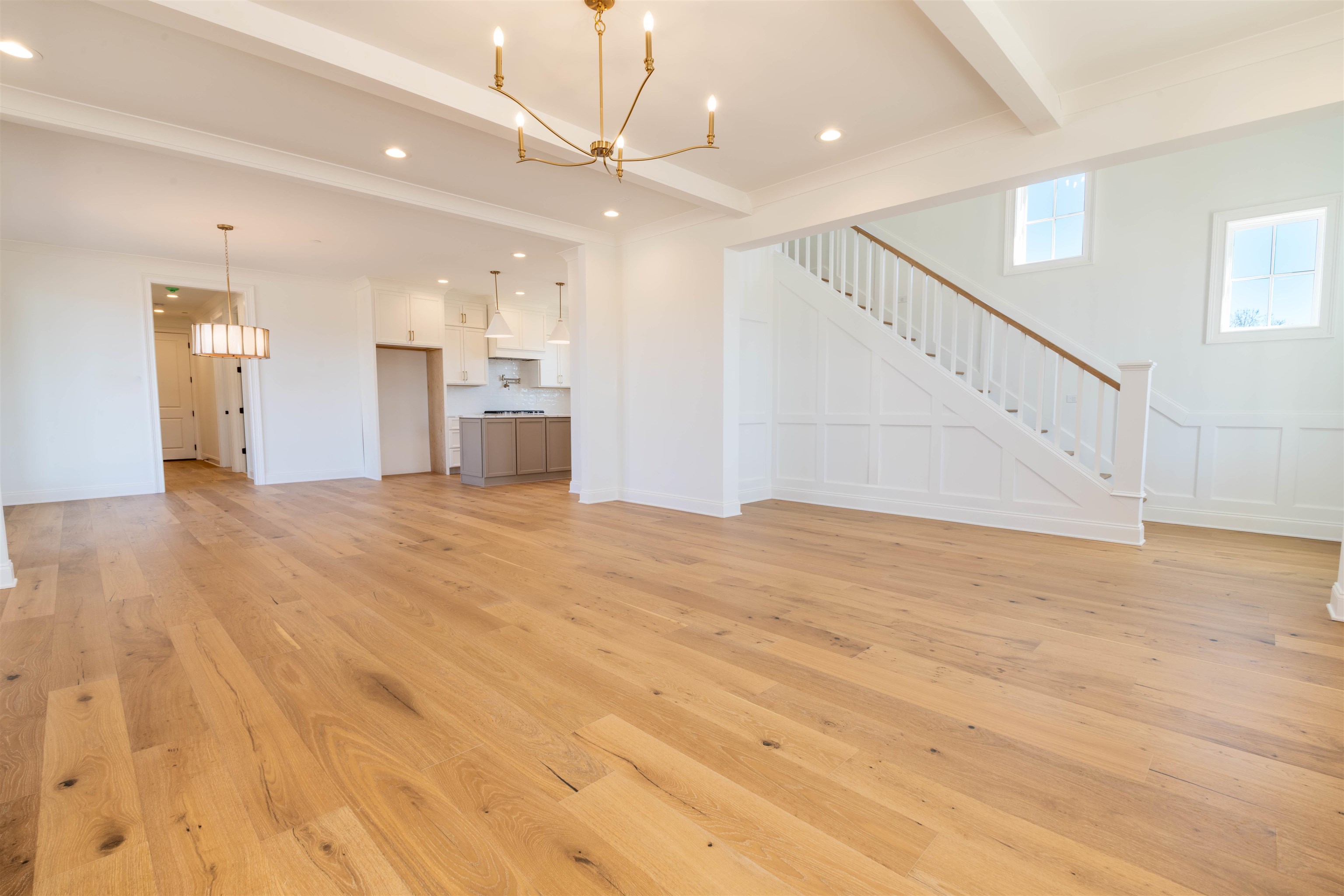 30 Rambling Rex Trail Piperton, TN 38017 - Photo 15 of 25 Unfurnished living room with light wood finished floors, beam ceiling, recessed lighting, stairs, and a chandelier